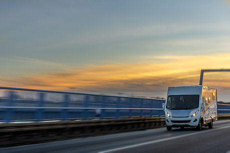 motorhome-races-across-bridge-sunset-dream-roadtrip.jpg